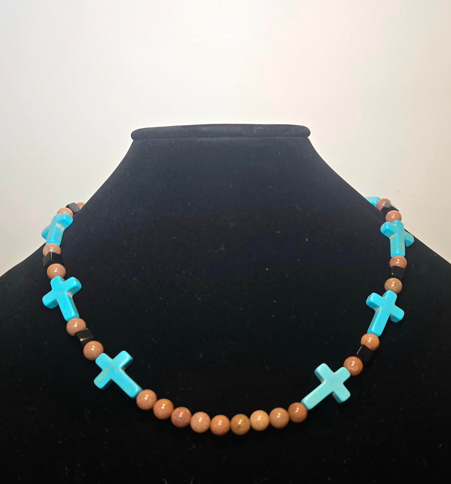 New Mexico short neckless with turquoise crosses square black beads and light brown beads.